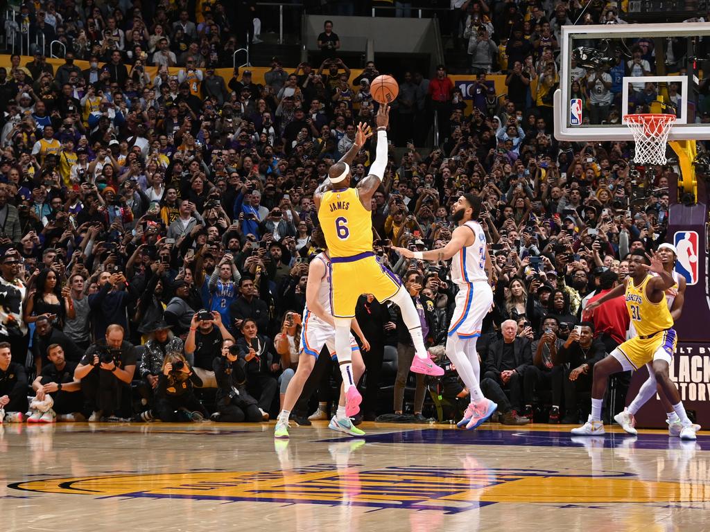 The iconic photo of LeBron James shooting the fadeaway jumper to break the all-time scoring record, with the crowd watching in awe.